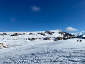 two people are skiing down a snow covered slope at La casa nel bosco-Val Granara guesthouse in Filettino Graziani
