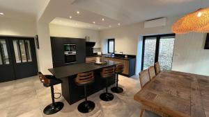a kitchen and dining room with a counter and a table at Chez Max - Terrasse - Climatisation - Parking gratuit in Beaune