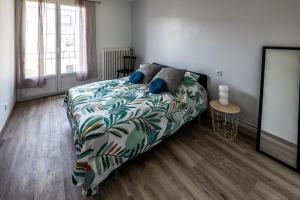 a bedroom with a bed with a colorful comforter at Appartement paisible au bord de l Isle avec parking in Périgueux