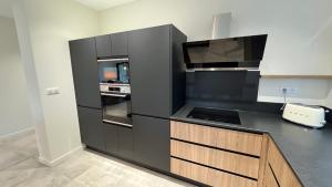 a kitchen with a black and wooden counter top at Chez Max - Terrasse - Climatisation - Parking gratuit in Beaune