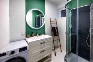 a bathroom with a sink and a shower and a mirror at Appartement paisible au bord de l Isle avec parking in Périgueux