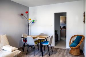 a dining room with a table and chairs at Appartement paisible au bord de l Isle avec parking in Périgueux +7 photos