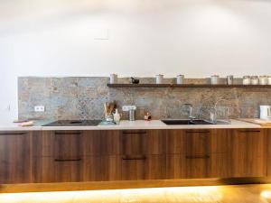 a kitchen with wooden cabinets and a sink at Molino Arroyo in Guájar-Faragüit