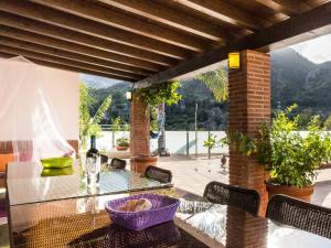 a glass table and chairs on a patio with a view at Molino Arroyo in Guájar-Faragüit