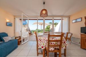 a living room with a table and chairs and a couch at Appartement Arzon in Arzon