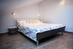 sypialnia z łóżkiem z niebiesko-białą kołdrą w obiekcie Apartments Centener w Rovinj
