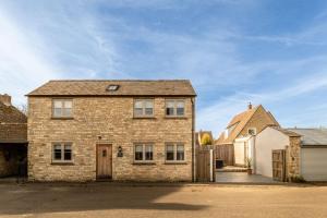 une maison en briques avec un garage et une allée dans l'établissement King's Cottage, à Wootton