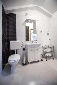 biała łazienka z toaletą i umywalką w obiekcie Apartments Centener w Rovinj +37 zdjęć