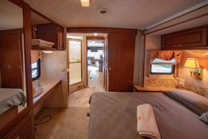 a small room with a bed and a television at ATHENS MOTORHOME park RV WINNEBAGO in Pallíni +18 photos