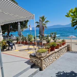 un patio con sombrilla, plantas y el océano en Apartmani Cool & Chill, en Gradac