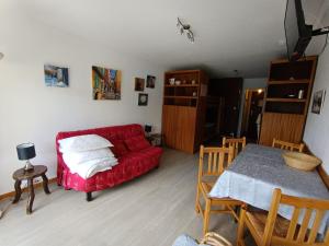 un salon avec un canapé rouge et une table dans l'établissement Studio exposé sud avec balcon, à 200m des pistes et commerces, animaux acceptés - FR-1-445-26, à Montgenèvre
