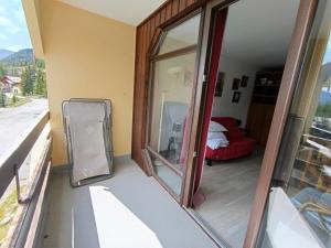Cette chambre comprend une fenêtre, un lit et un miroir. dans l'établissement Studio exposé sud avec balcon, à 200m des pistes et commerces, animaux acceptés - FR-1-445-26, à Montgenèvre