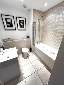 a bathroom with a tub and a toilet and a sink at Seaview Hideway - Abnb in Portstewart