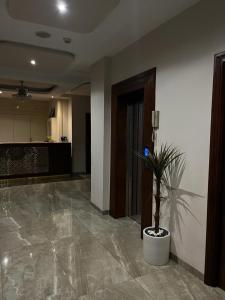 a lobby with a potted plant in the middle at Pacha hotel in Sfax
