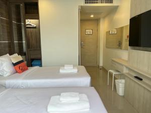 a hotel room with two beds and a flat screen tv at Centro One Bangla in Patong Beach
