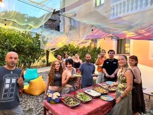 a group of people standing around a table with food at Tias Hostel in Shkodër