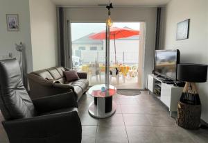 a living room with a couch and a table with an umbrella at Chez nicolas in Sendets
