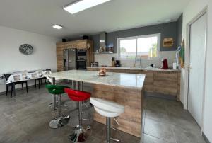a kitchen with a large island with bar stools at Chez nicolas in Sendets +17 photos