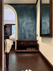 a bedroom with a dresser and a large painting on the wall at Sengphachanh Heritage Boutique in Luang Prabang
