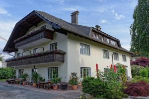 a large white house with a balcony and tables at Mörtbauerhof und Haus Frühauf in Seeboden