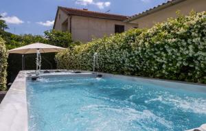 a swimming pool with an umbrella in a yard at Villa Gigi by Villas Guide in Poreč