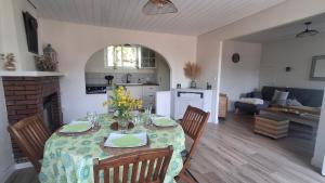a kitchen and dining room with a table and chairs at La ferme de beau soleil Gîte et cabanes in Saint-Gilles-du-Mené