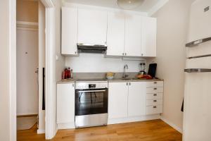 a small kitchen with white cabinets and a stove at The Best Apartment in Stylish Sodermalm Stockholm in Stockholm