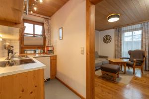 a kitchen and living room with a couch and a table at Mörtbauerhof und Haus Frühauf in Seeboden +99 photos