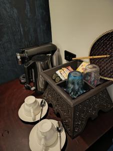 a table with cups and plates and a coffee maker at Sengphachanh Heritage Boutique in Luang Prabang