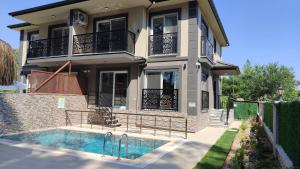a house with a swimming pool in front of it at Villa BB Mugla 2 in Ortaca