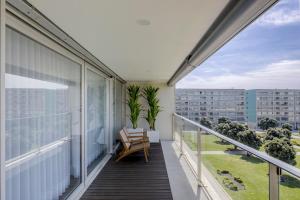 ein Balkon mit einem Stuhl und Blick auf ein Gebäude in der Unterkunft SONIA Travels in Matosinhos