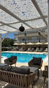 a swimming pool with chairs and a building at Sarti Plaza in Sarti +25 photos