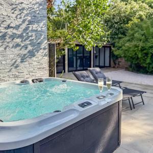 a hot tub with two glasses of wine at Villa avec jacuzzi, sauna&cinéma in Triel-sur-Seine