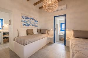 a bedroom with a bed and a chandelier at Mediterranea Blu in Triovasálos