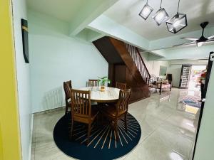 a dining room with a table and chairs at Bayan 10 Homestay, Ayer Keroh Guest House - 4bedrooms, 15minutes to town in Kampong Bukit Katil