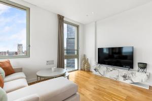 a white living room with a large flat screen tv at Luxury Penthouse Stratford City in London