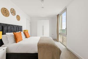 a bedroom with a large bed and a large window at Luxury Penthouse Stratford City in London