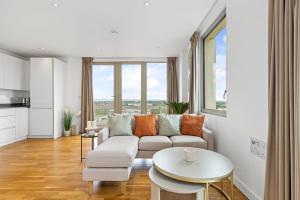 a living room with a couch and a table at Luxury Penthouse Stratford City in London