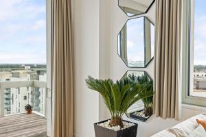 a living room with a mirror and a plant at Luxury Penthouse Stratford City in London