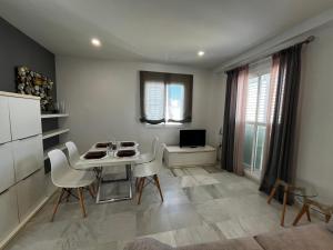 een eetkamer met een tafel en stoelen in een kamer bij CONIL CENTRO MERCURIO solo FAMILIAS in Conil de la Frontera