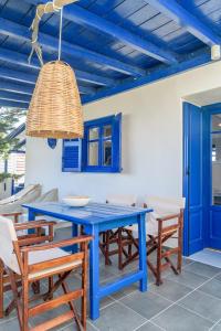 a blue dining room table with chairs and a light fixture at Mediterranea Blu in Triovasálos