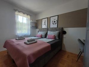 a bedroom with a large bed with pink sheets at 16 Čižići in Čižići