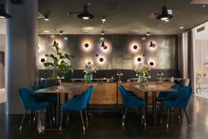 Un comedor con mesas y sillas azules. en Hotel Matts, en Espoo
