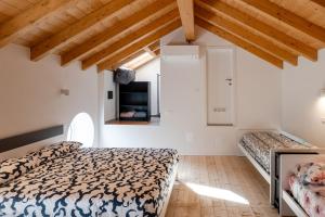 a bedroom with two beds in a room with wooden ceilings at Casa Quadrifoglio - Ticino in Intra
