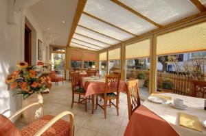 a dining room with tables and chairs and windows at Mörtbauerhof und Haus Frühauf in Seeboden