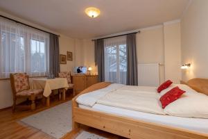 a bedroom with a large bed and a dining room at Mörtbauerhof und Haus Frühauf in Seeboden