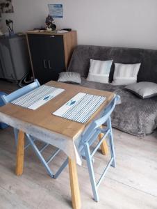 a wooden table and a chair in a living room at Studio confortable à Dolus-d'Oléron 26 m² avec piscine in Dolus-d'Oléron