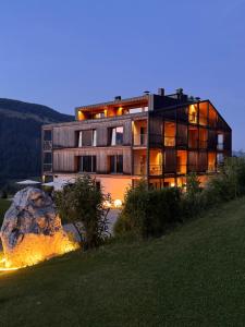 a large building with a rock in front of it at Gailerhof Boutique Hotel B&B Dolomites in Monguelfo