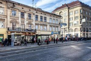 リヴィウにあるАпартаменти для сім'ї з видом на Оперний театрの建物前の道を歩く人々