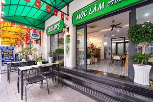 フーコックにあるMoc Lam Homestay GrandWorld Phu Quocの店前のテーブルと椅子のあるレストラン